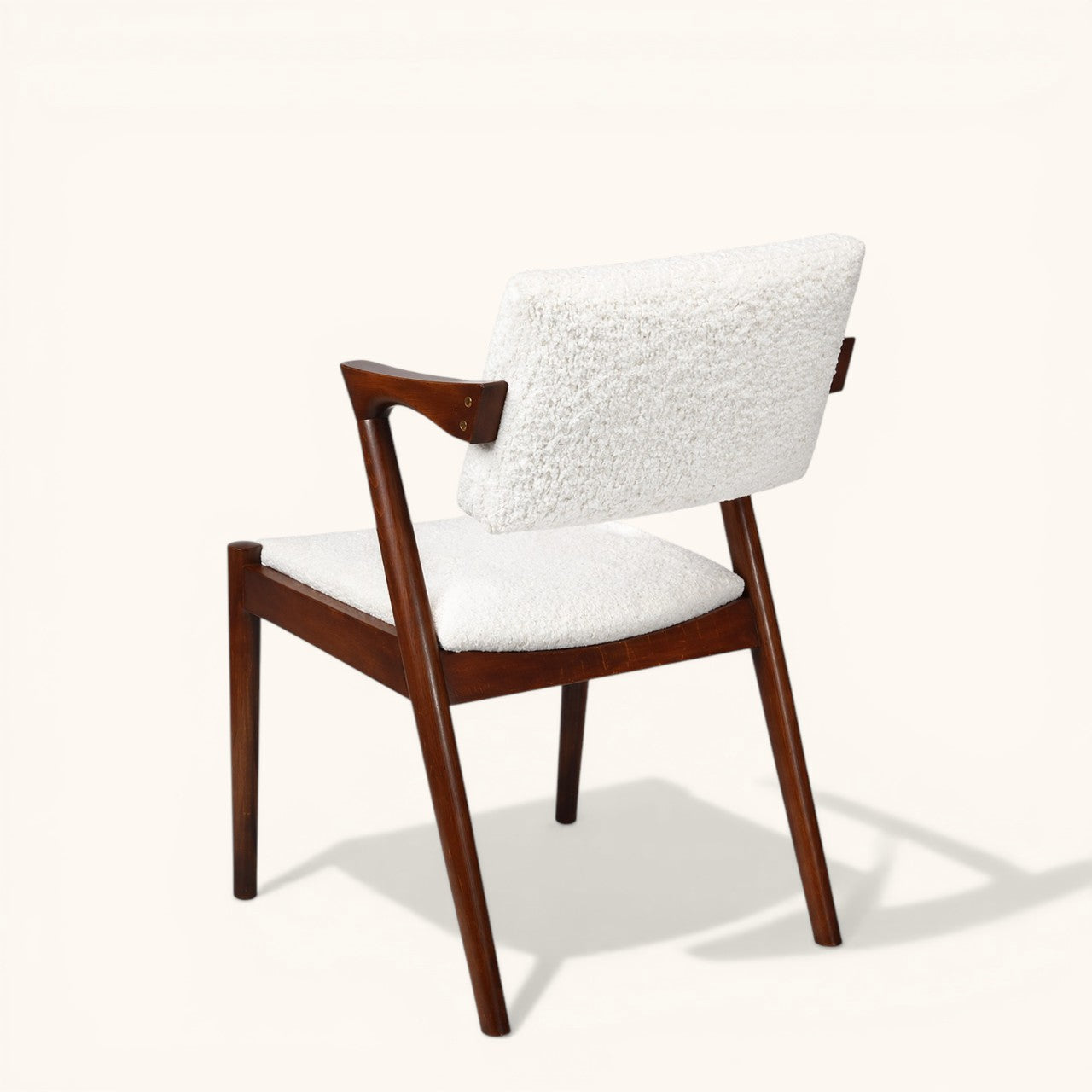 Esszimmerstuhl mit dunklem Holzgestell, gepolstertem Sitz und Rückenlehne, erhältlich in blauem Stoff oder weißem Bouclé, moderner Designerstuhl für Esszimmer und Wohnbereich