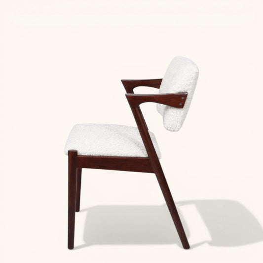Esszimmerstuhl mit dunklem Holzgestell, gepolstertem Sitz und Rückenlehne, erhältlich in blauem Stoff oder weißem Bouclé, moderner Designerstuhl für Esszimmer und Wohnbereich