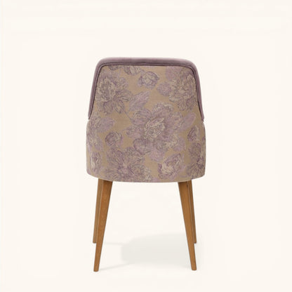 Stuhl in soft lilac mit weich geschwungener Rückenlehne, integrierten Armseiten, floraler Rückseite und schlanken Holzbeinen