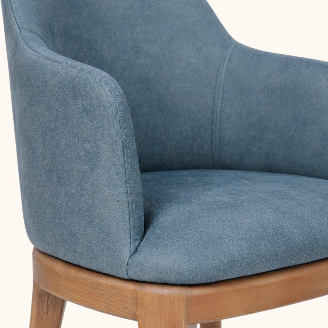 Stuhl mit hellbraunem Holzgestell und blau gepolsterter Sitzschale, hoher Rückenlehne und integrierten Armlehnen, moderner Designerstuhl für Wohnbereich und Esszimmer